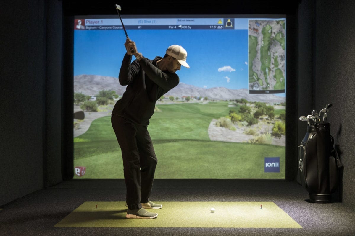 man playing golf in golf simulator